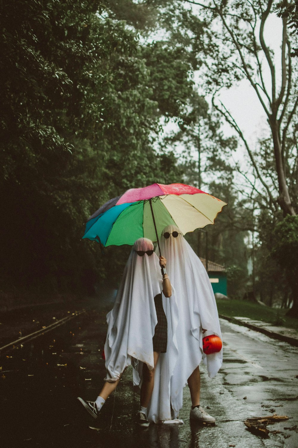 a couple of people walking down a street holding umbrellas