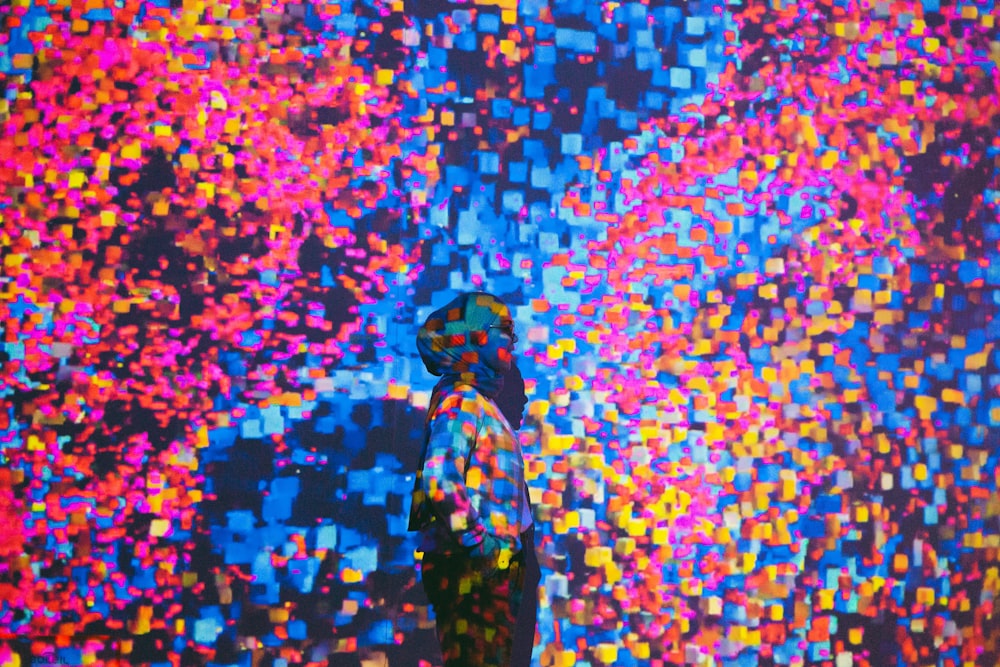 a man standing in front of a colorful wall