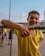 A cheerful child wearing a bright football jersey, smiling on a sunny playground.