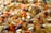 A close-up view of a colorful assortment of various grains and seeds, including lentils, beans, and rice. The image showcases a vibrant mix of orange, yellow, and dark brown colors, emphasizing the texture and variety of the ingredients.