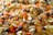 A close-up view of a colorful assortment of various grains and seeds, including lentils, beans, and rice. The image showcases a vibrant mix of orange, yellow, and dark brown colors, emphasizing the texture and variety of the ingredients.