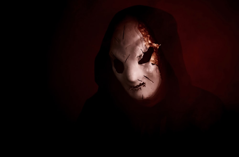 a person wearing a scary mask in the dark