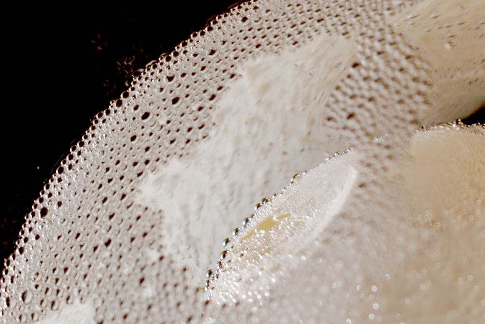 um close up de um objeto branco com um fundo preto