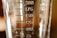 A close-up view of a transparent measuring container with measurement markings ranging from 75 to 200 milliliters. The surface of the container appears reflective with some light and shadow play.