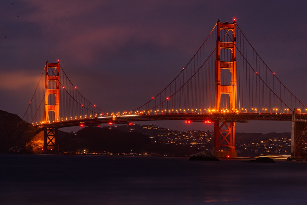 the golden gate bridge is lit up at night