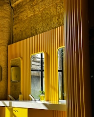 A freshly remodeled bathroom featuring sleek fixtures and warm yellow accents.