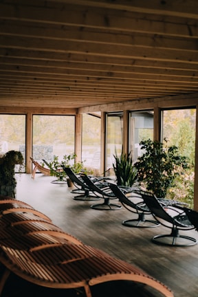 A tranquil spa lounge featuring cozy seating and natural greenery near large windows.