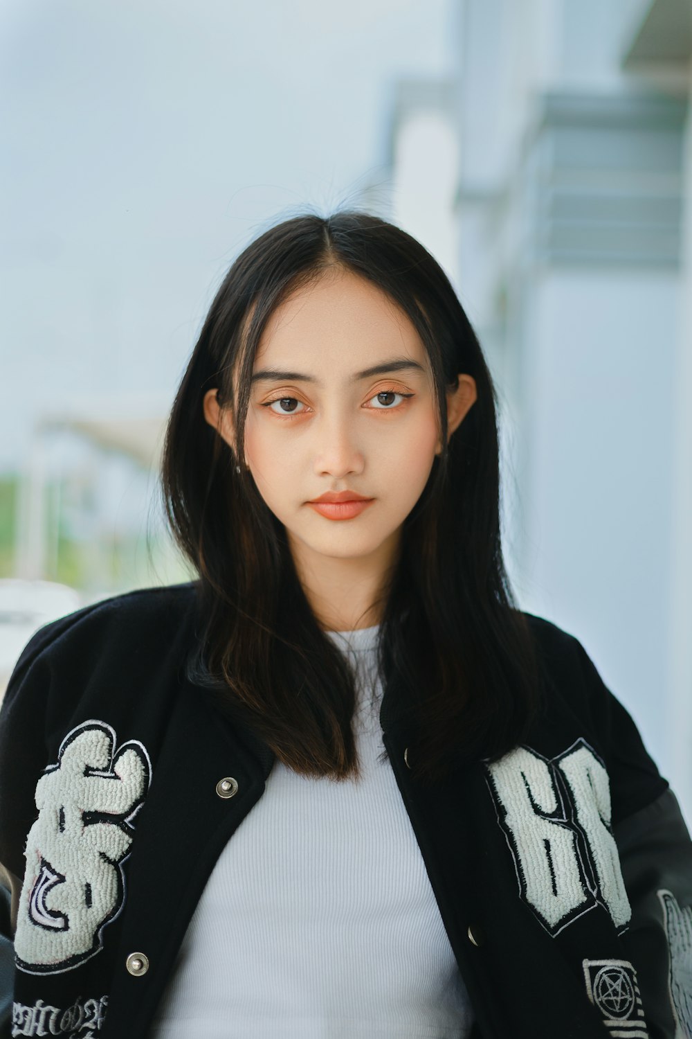 a woman with long black hair wearing a black jacket