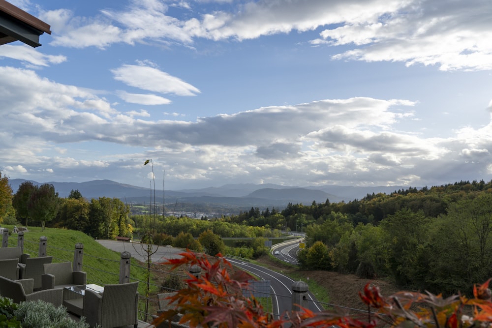 a scenic view of a country road and mountains