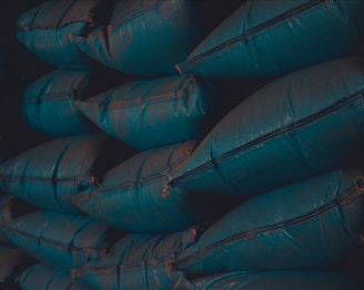 Stacked bags of blue boss aqua needs feed neatly arranged in a warehouse.