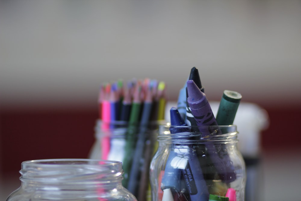 a jar filled with lots of different colored pencils