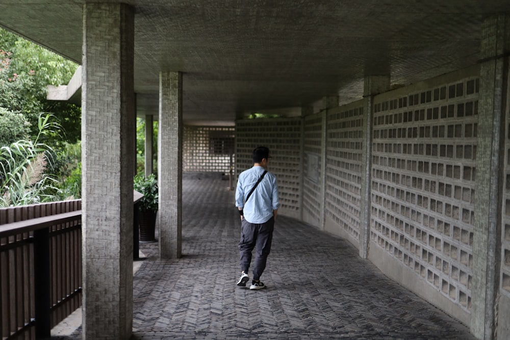 a man walking down a walkway in a building