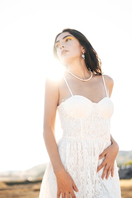 Warm sunlight casting shadows over a neatly folded linen dress paired with delicate pearl earrings.