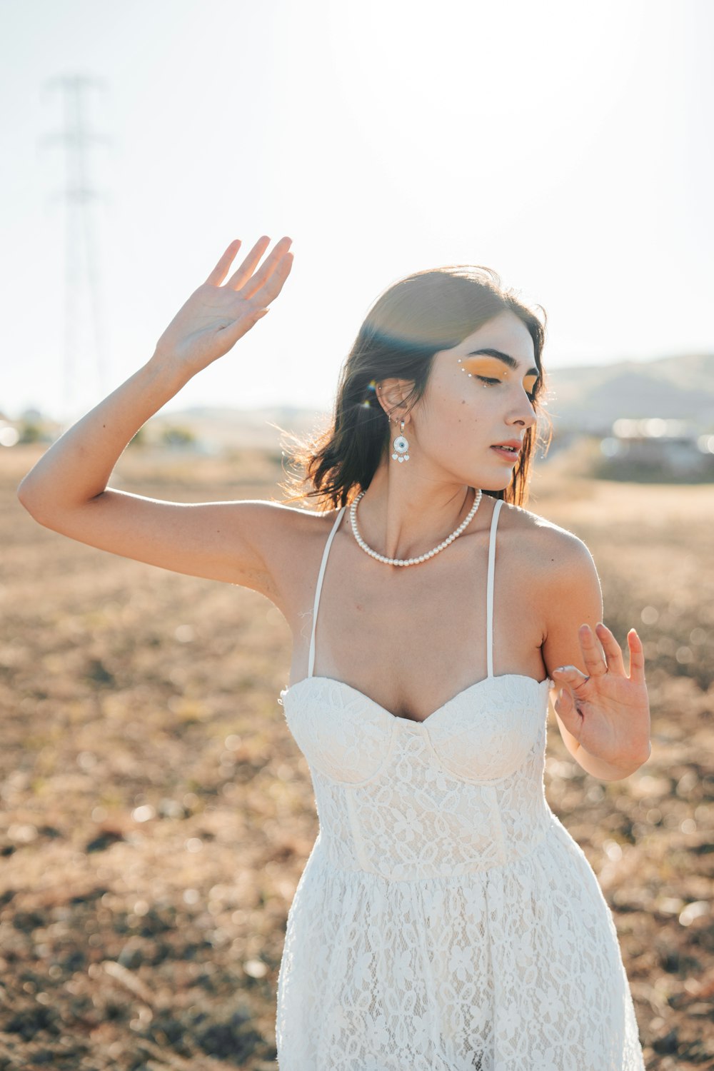 a woman in a white dress standing in a field