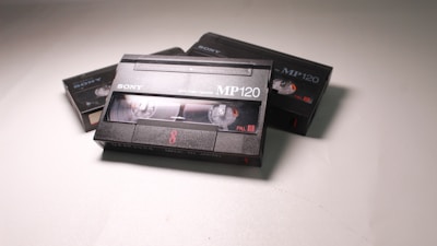 A collection of vintage video cassette tapes with the 'Sony' brand. The central focus is on a prominently displayed MP120 tape, with others partially visible in the background. The tapes feature clear spools and are labeled with 'PAL' and '8'.