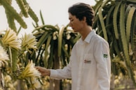 a man standing next to a bunch of flowers