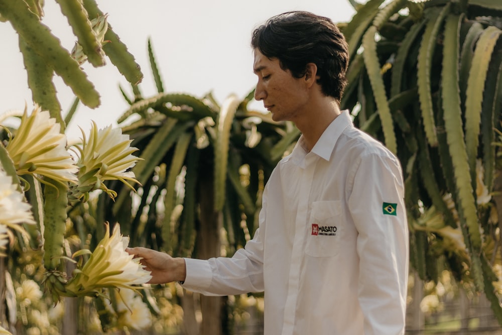 a man standing next to a bunch of flowers