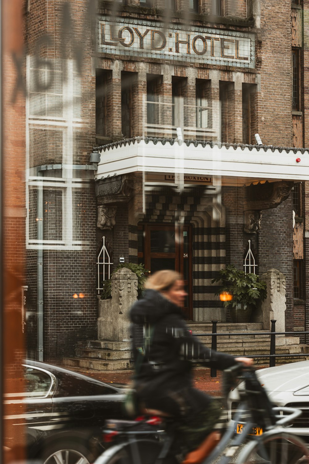 a woman riding a bike past a tall building