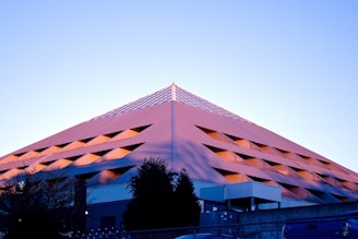 a tall pink building with a sky background