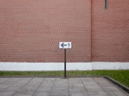 a brick wall with a street sign in front of it