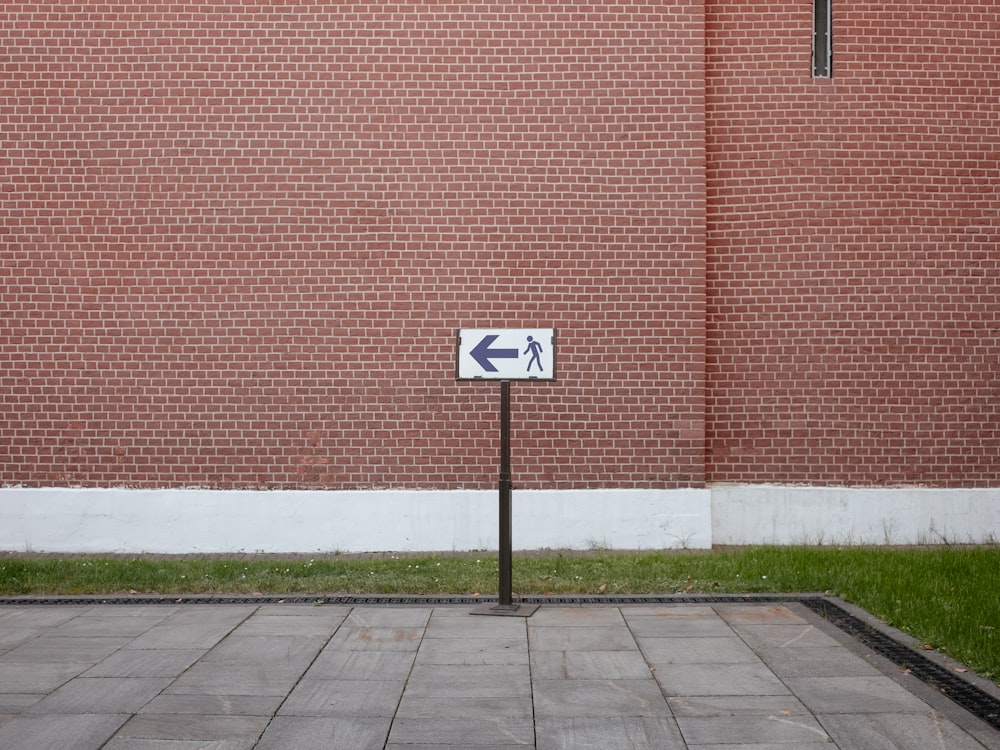 a brick wall with a street sign in front of it