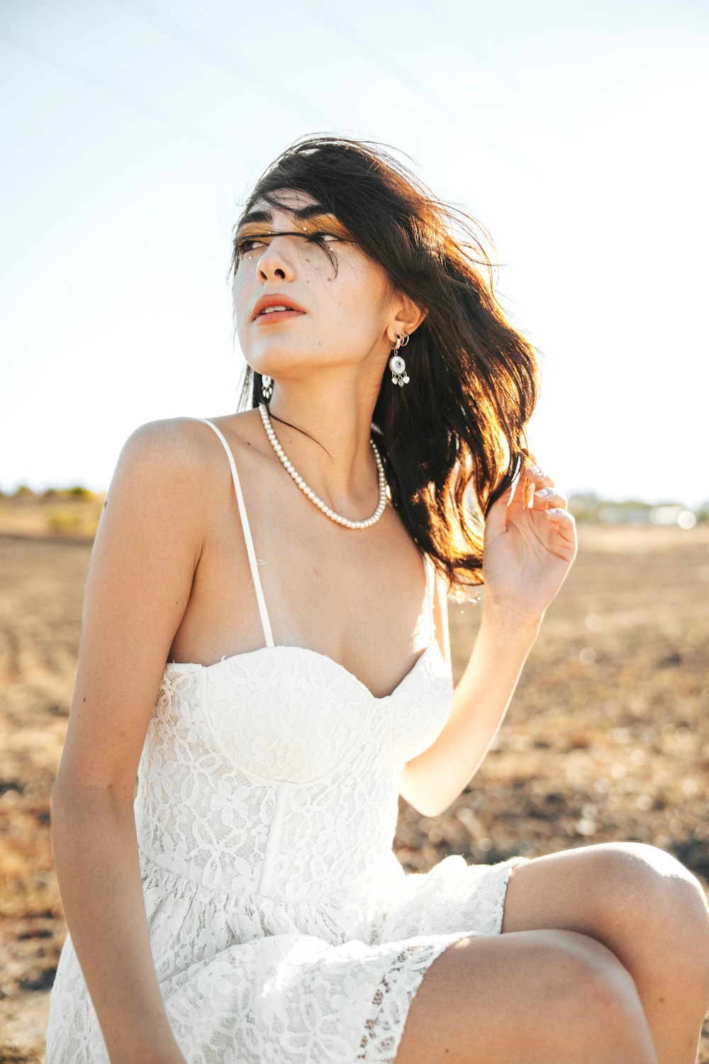 a woman in a white dress sitting on the ground