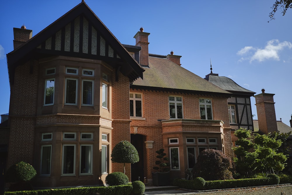 une grande maison en brique brune avec beaucoup de fenêtres