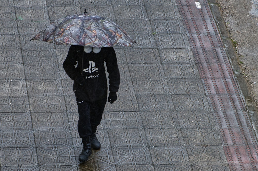 a person walking down a sidewalk with an umbrella