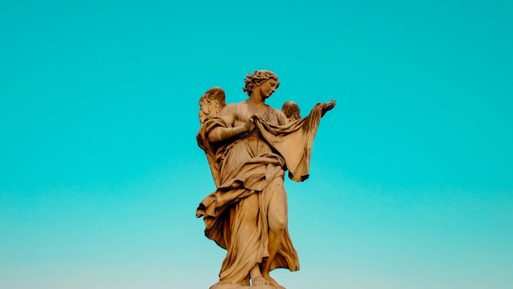 a statue of a woman holding a bird on top of a building