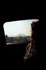 a woman sitting in a car looking out the window