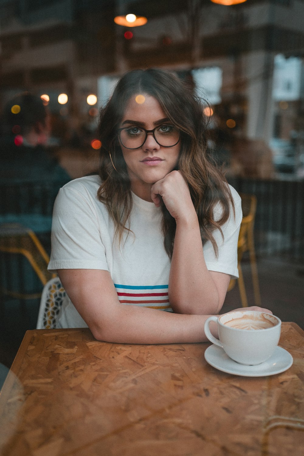 a woman sitting at a table with a cup of coffee