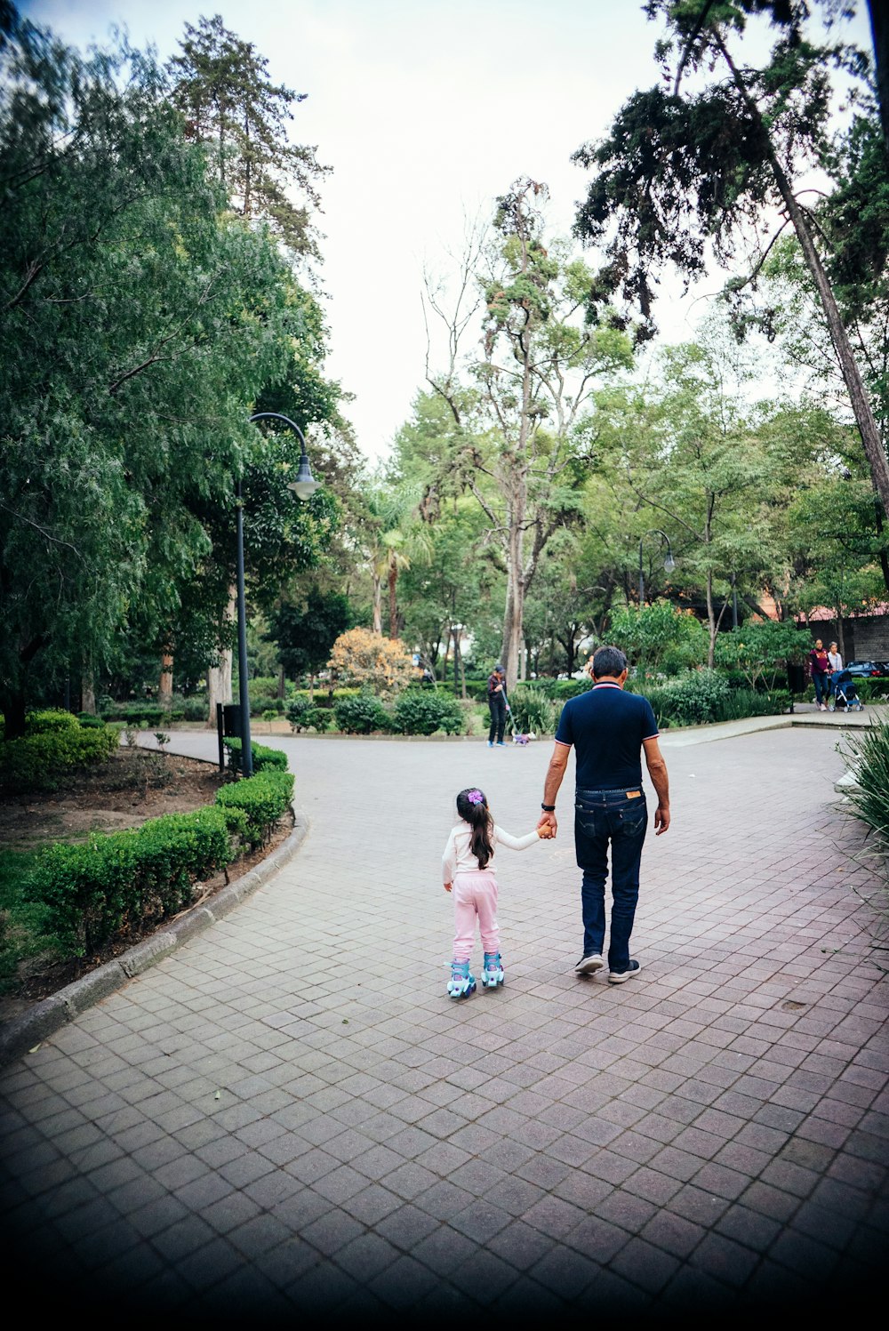un homme et une petite fille marchant sur un trottoir