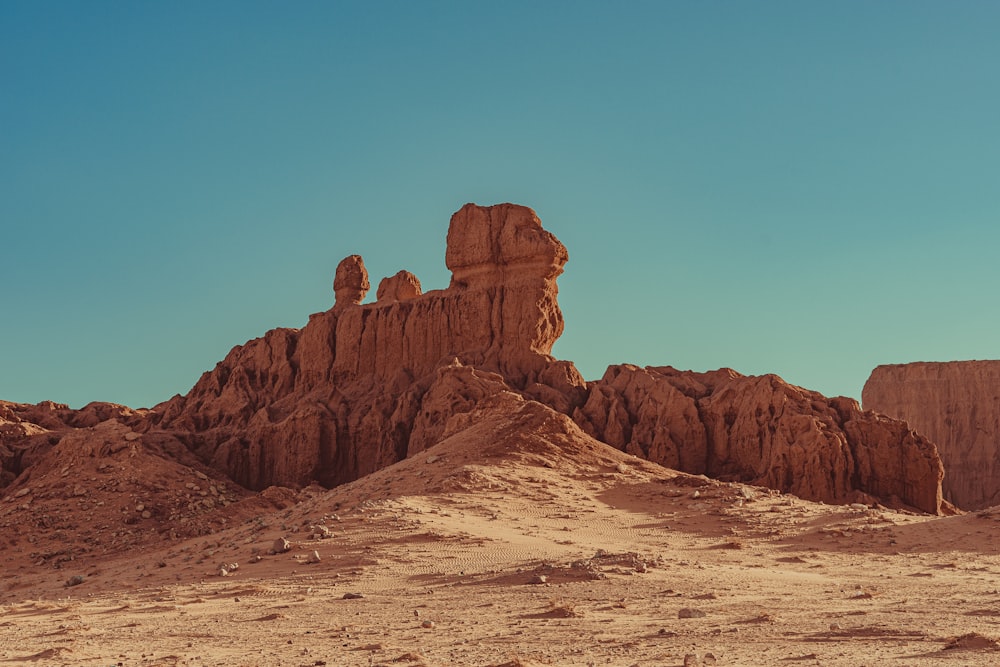 a large rock formation in the middle of a desert