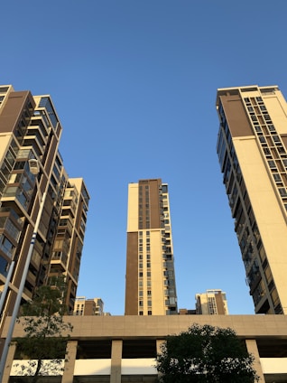 Modern residential buildings with green landscaping under a clear sky.