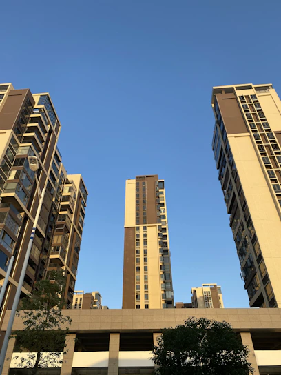 A modern urban development project blending green spaces and residential buildings under a clear sky.