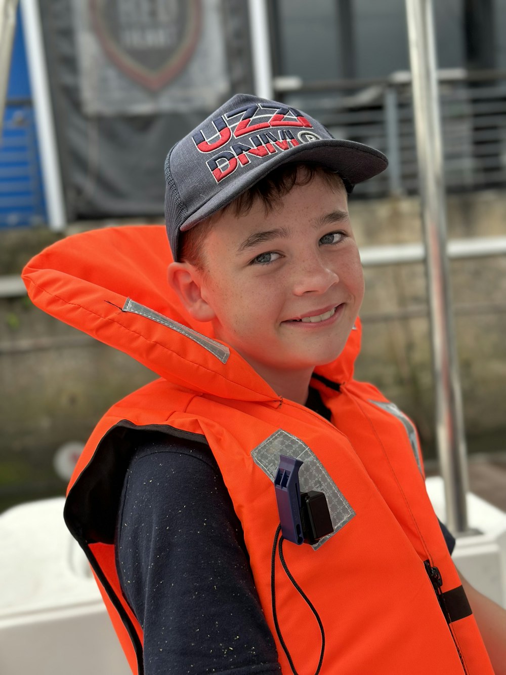 a young boy wearing an orange life jacket