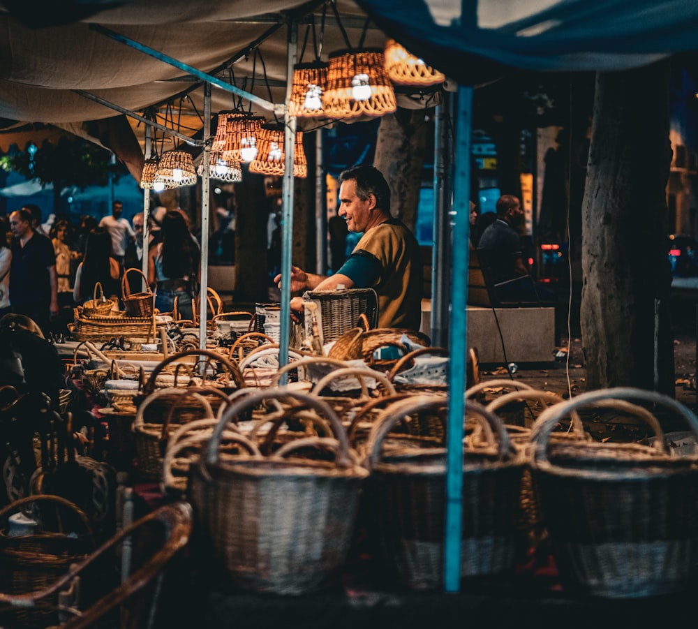 a man sitting at a table with baskets in front of him