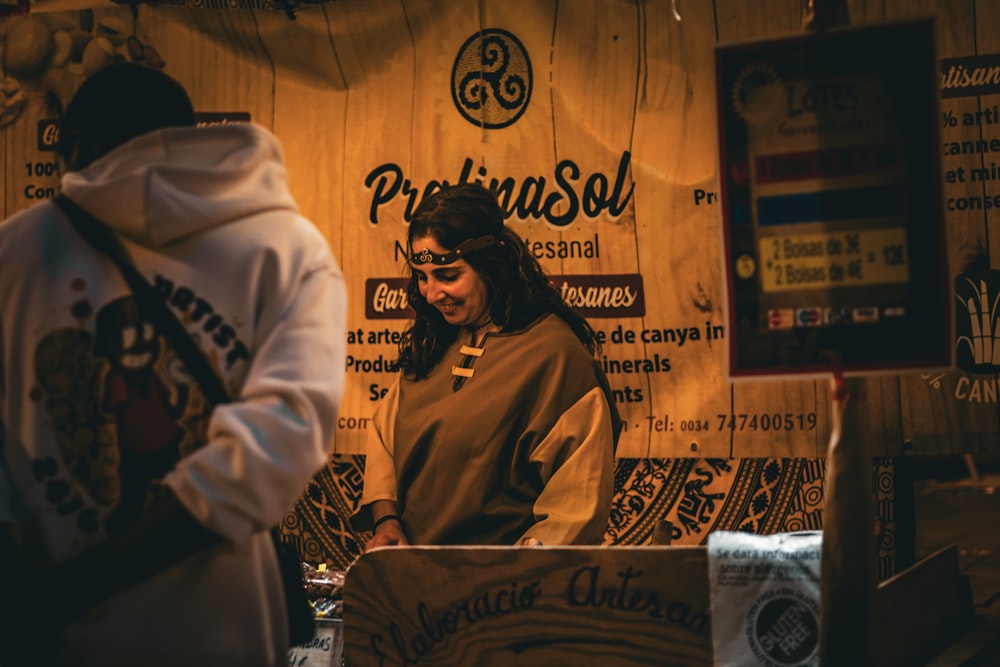 a woman standing in front of a wooden sign