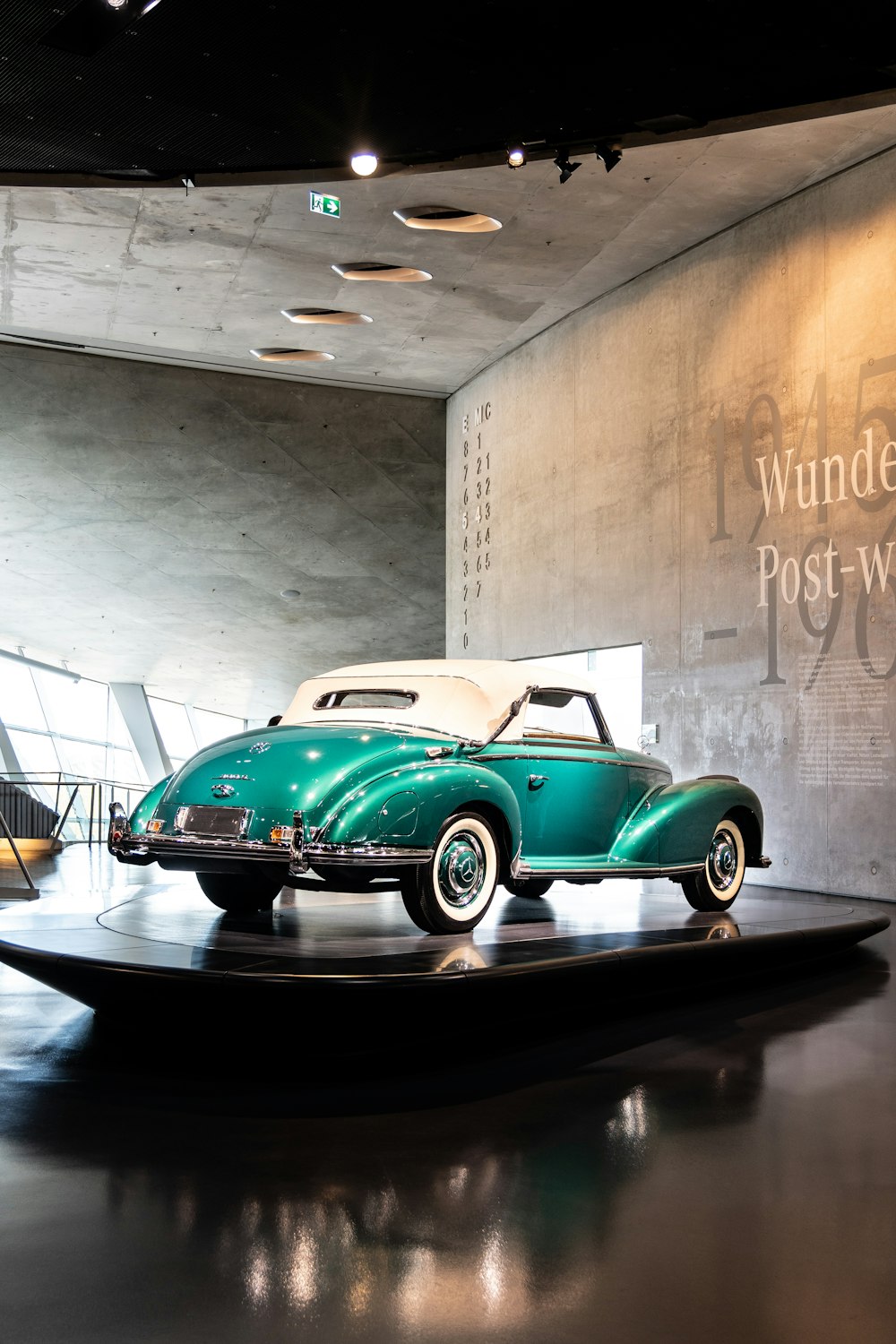 a green and white car on display in a museum