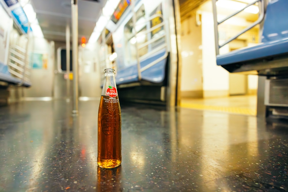 a bottle of soda sitting on a table in a train station