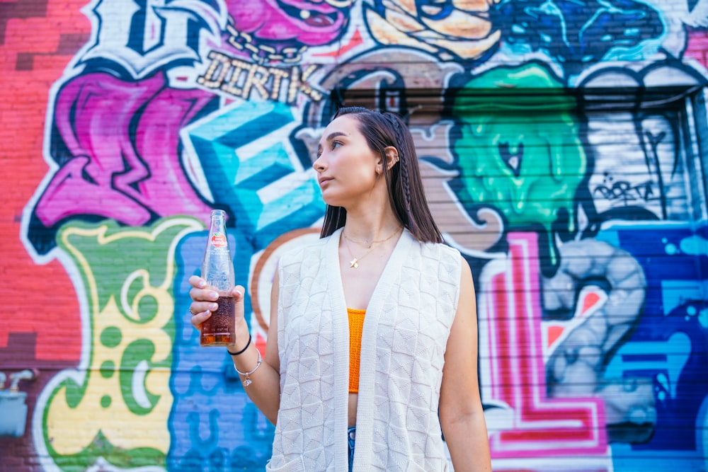 a woman standing in front of a wall with graffiti