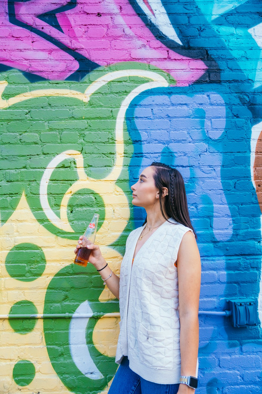 a woman standing in front of a colorful wall