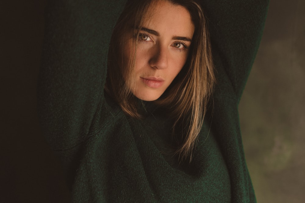 a woman in a green sweater posing for a picture