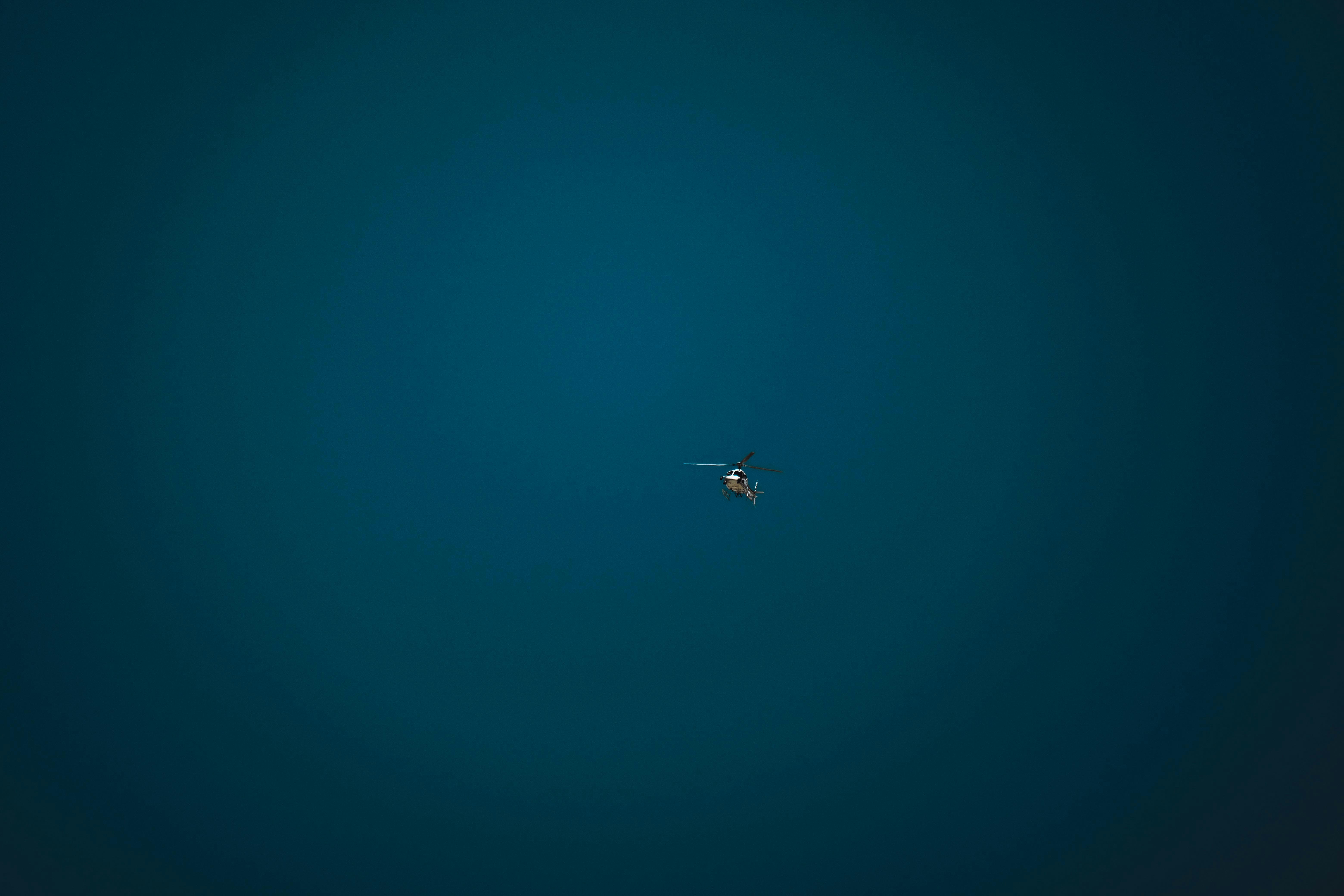 a small airplane flying through a dark blue sky
