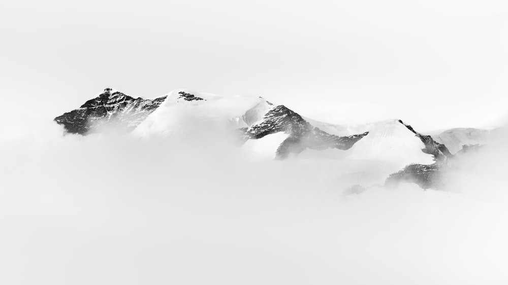 a black and white photo of snow covered mountains