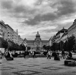 Black and white photo of a bustling city square with diverse crowds.