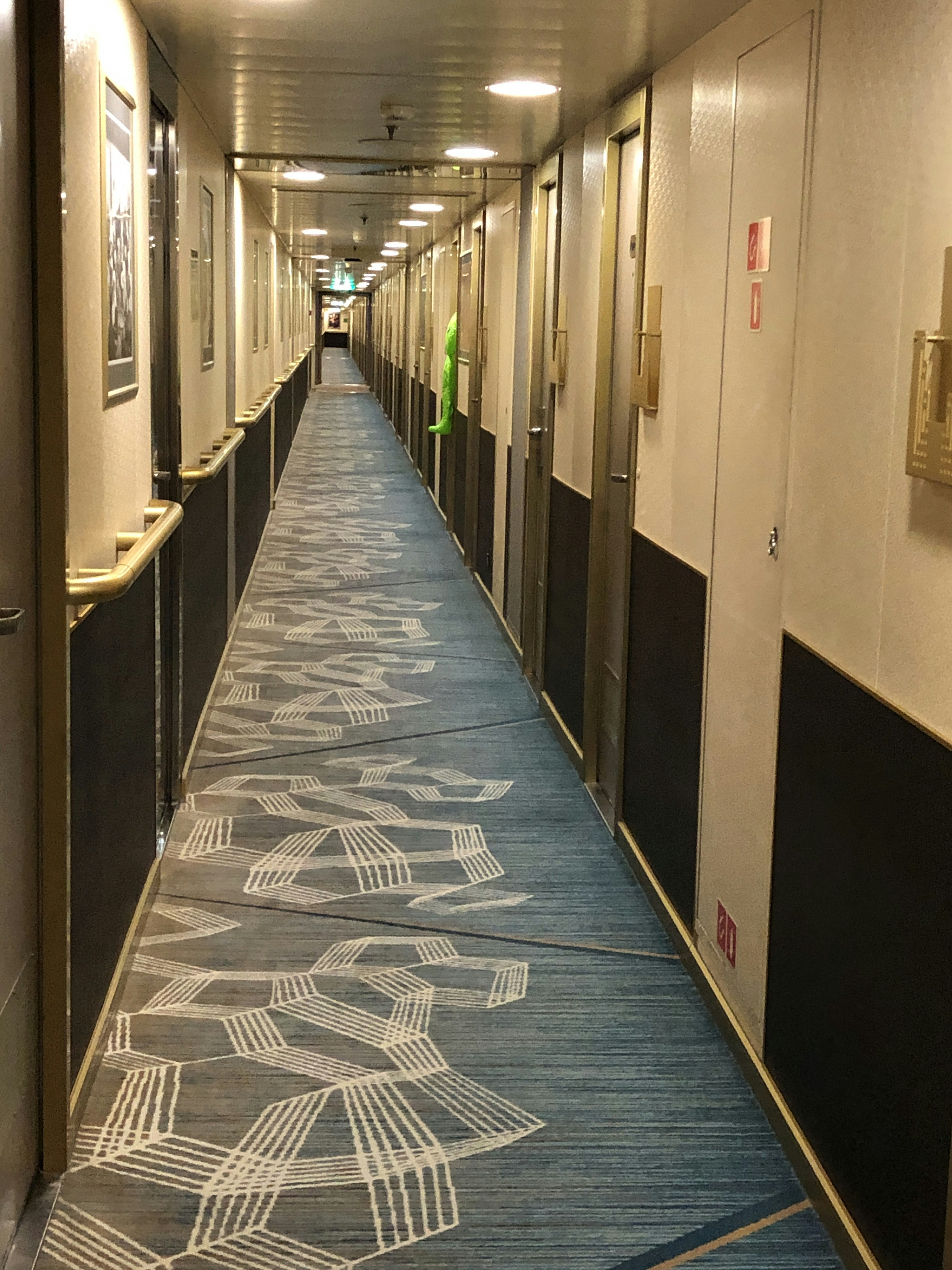 a long hallway with blue carpet and white walls