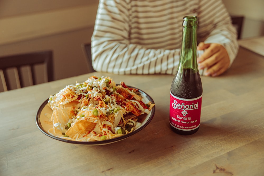 a plate of food and a bottle of beer on a table