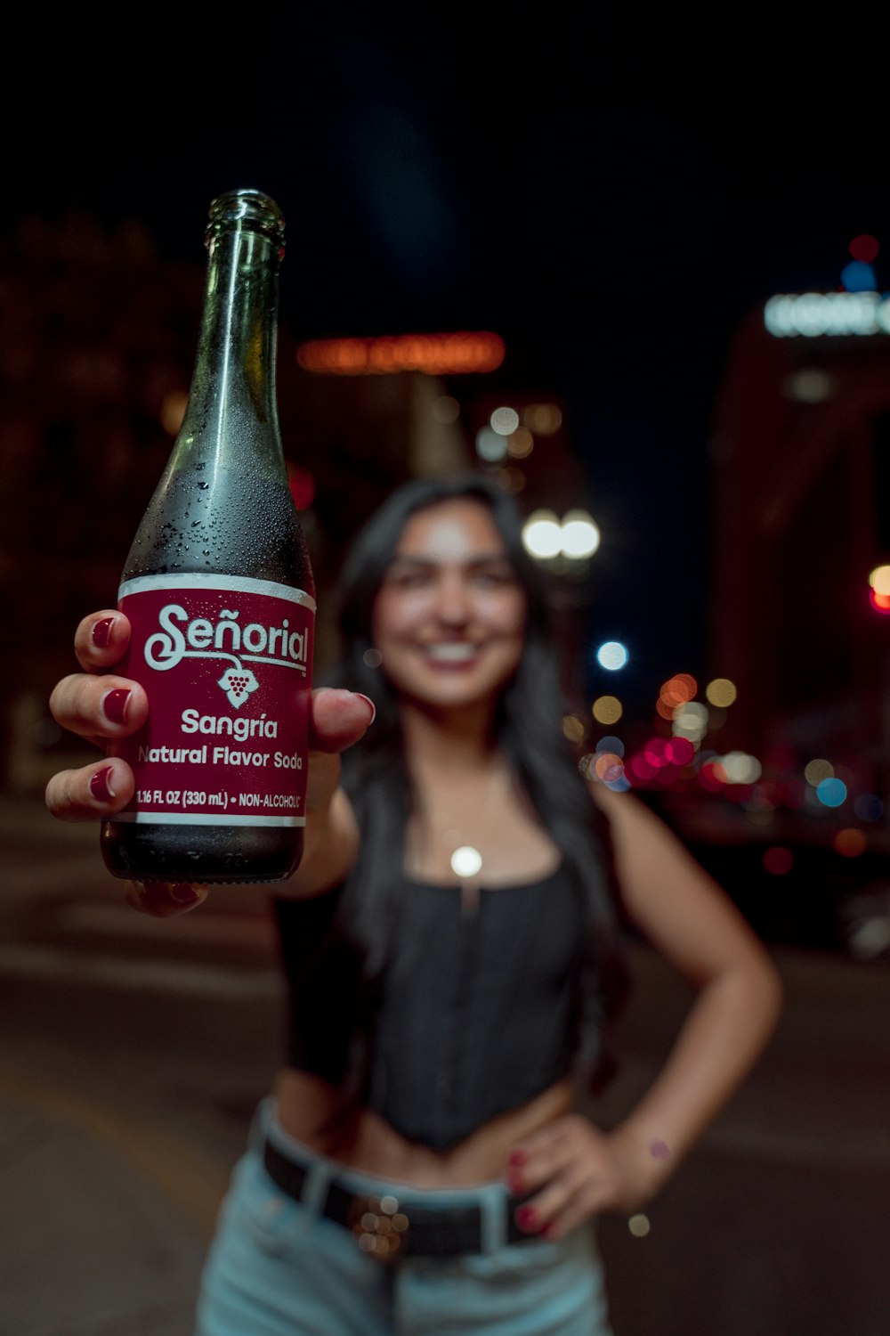 a woman holding a bottle of beer in her hand