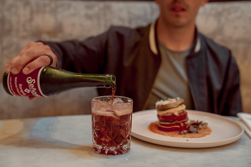 a man pouring a beverage into a glass